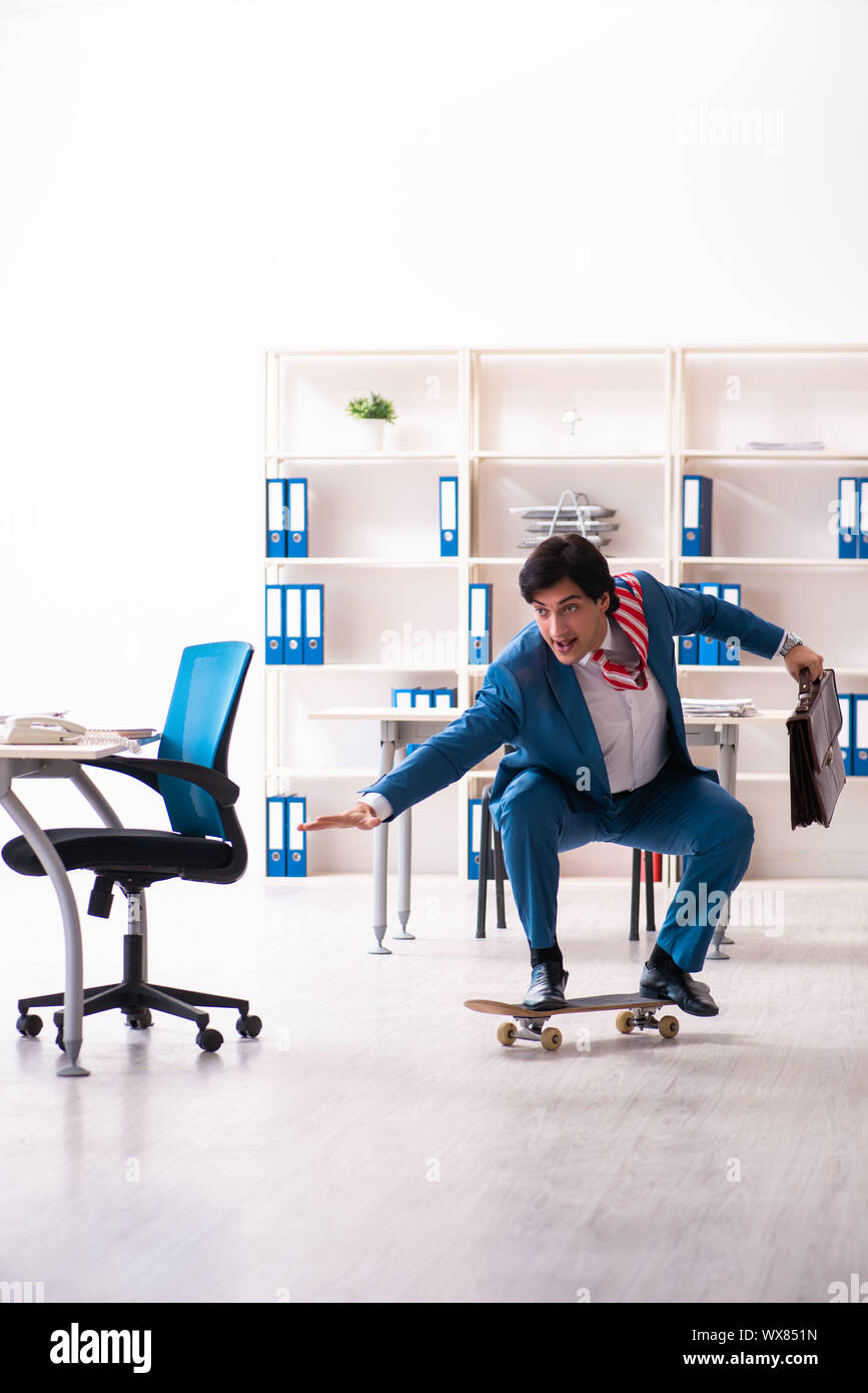 Young handsome businessman with longboard in the office Stock Photo - Alamy