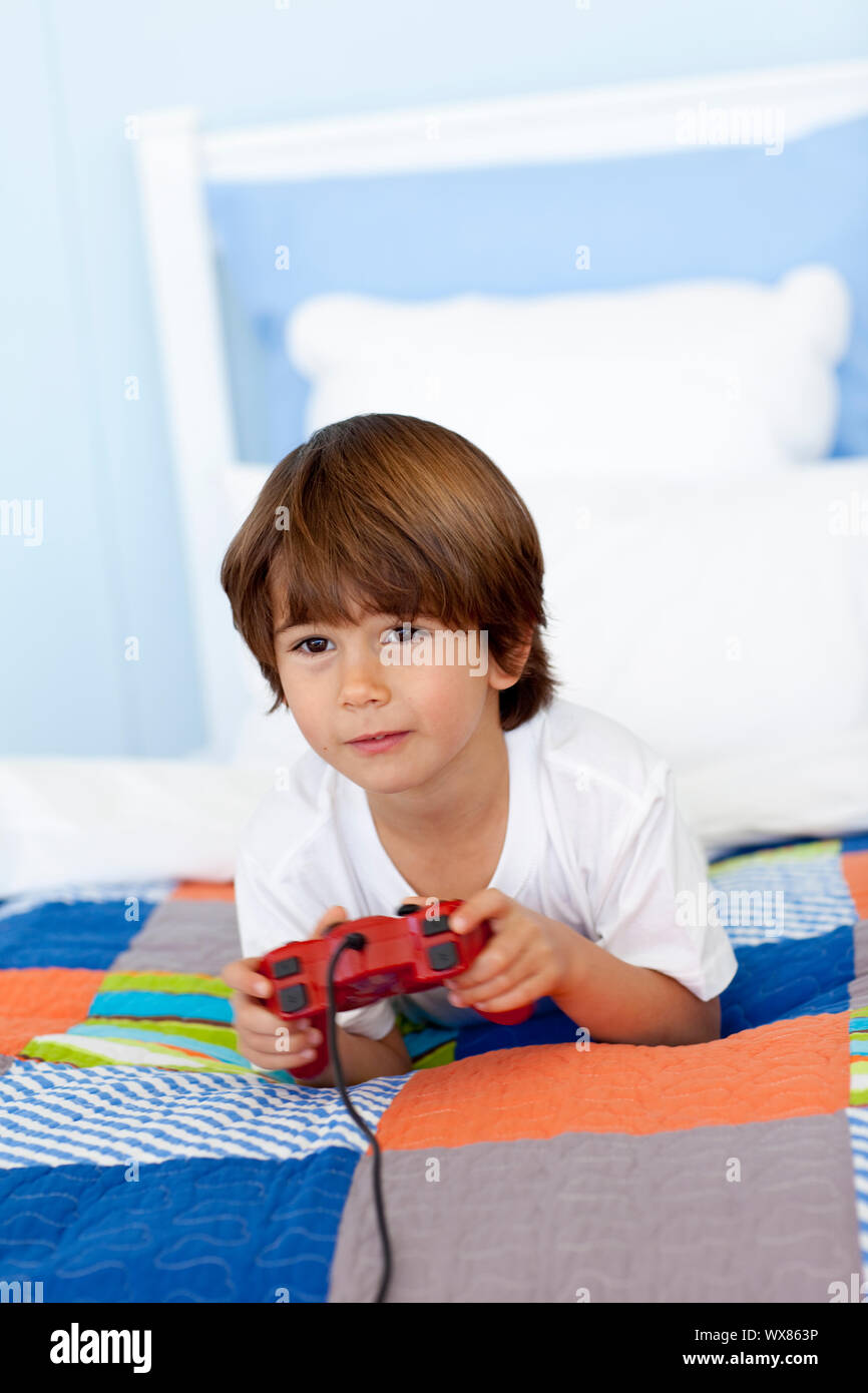 Boy lying in his bed playing videogames Stock Photo - Alamy