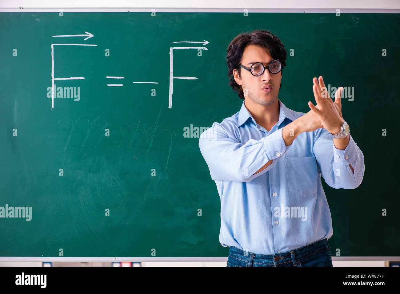 Young male physic standing in front of the green board Stock Photo