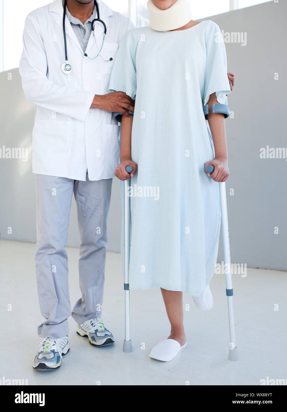 A physical therapist helping a patient with neck brace and on crutches