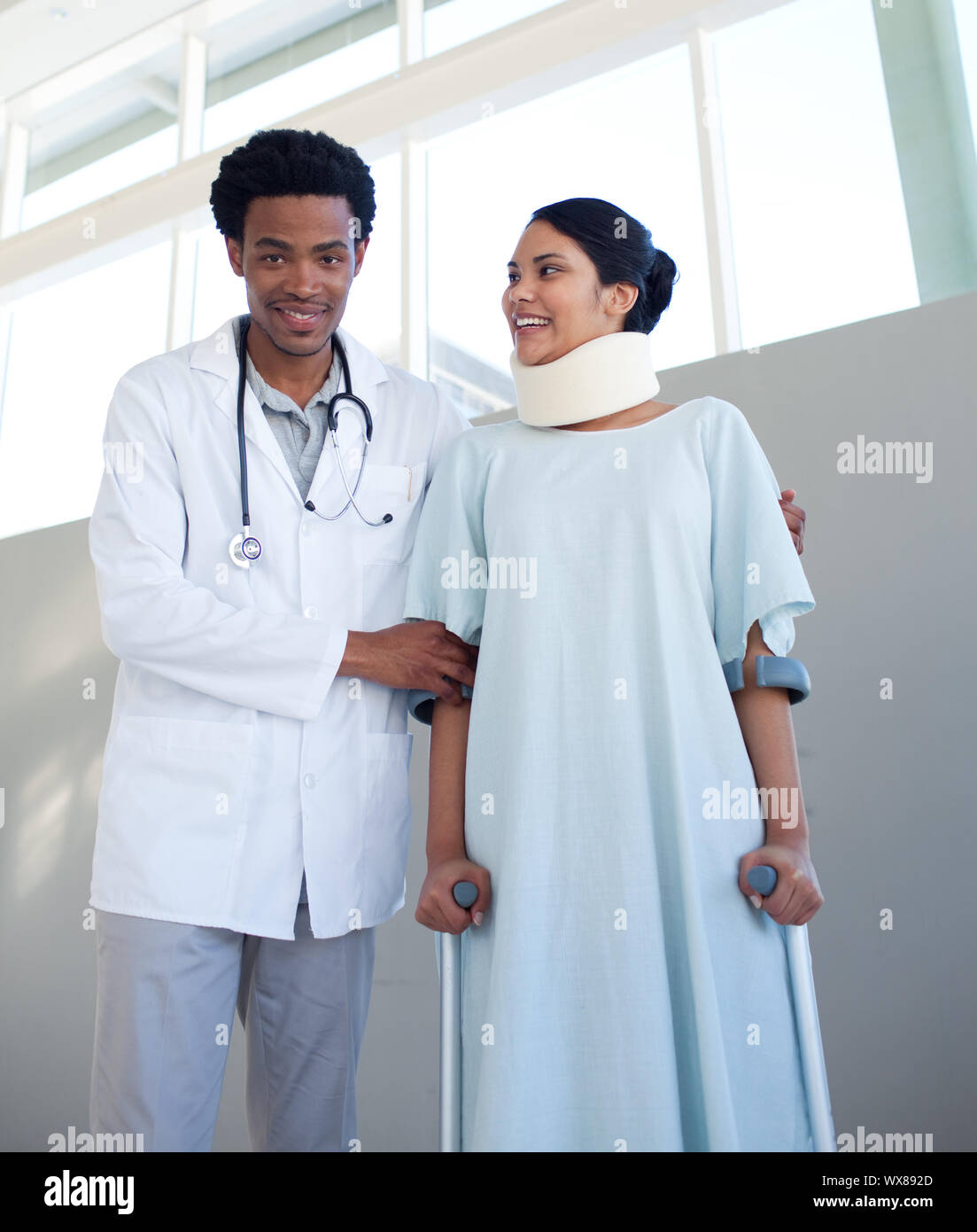 A doctor helping a patient with neck brace and on crutches in a