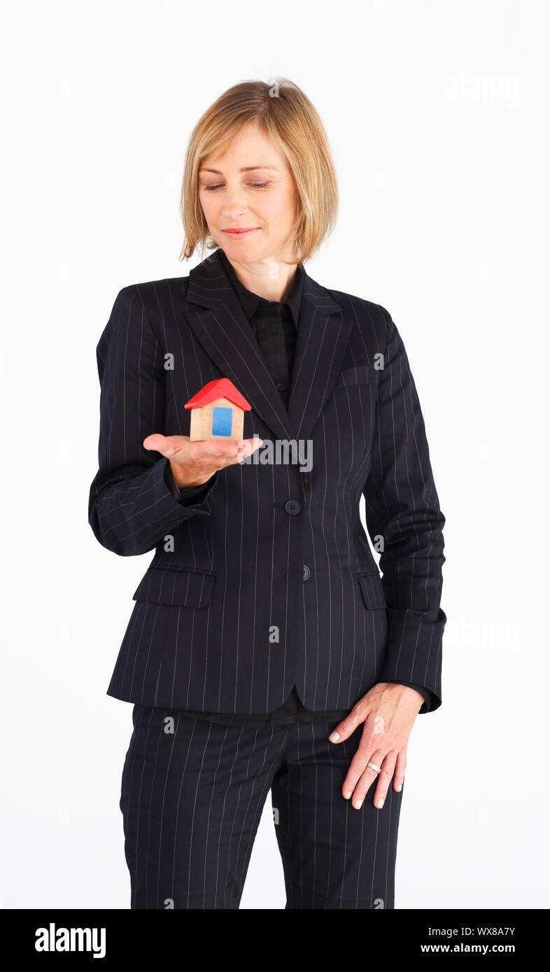 Happy businesswoman presenting a model of house Stock Photo - Alamy