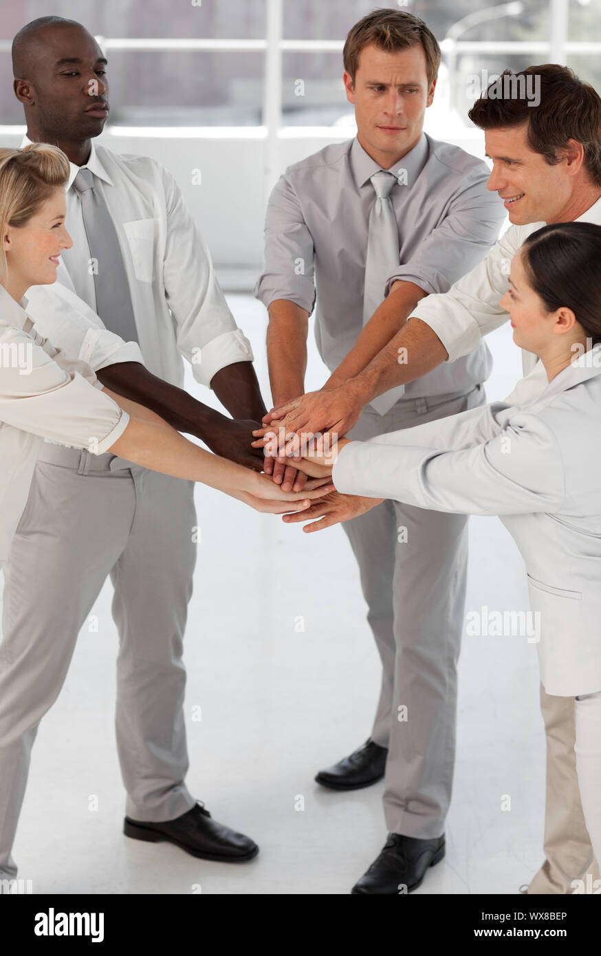 Close-up of smiling business team with hands together Stock Photo