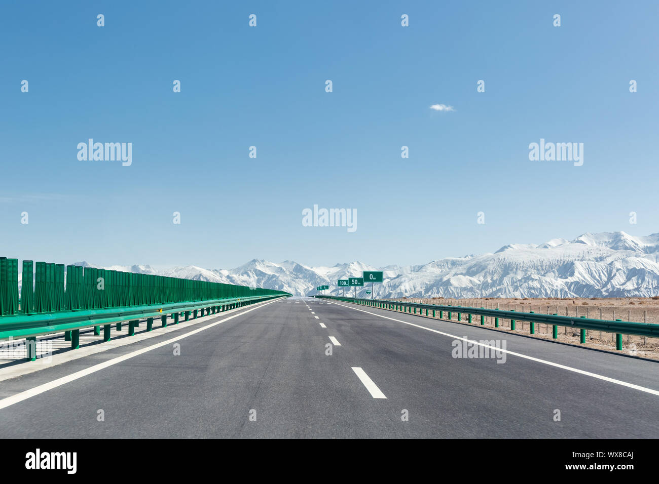 highway with snow mountains Stock Photo