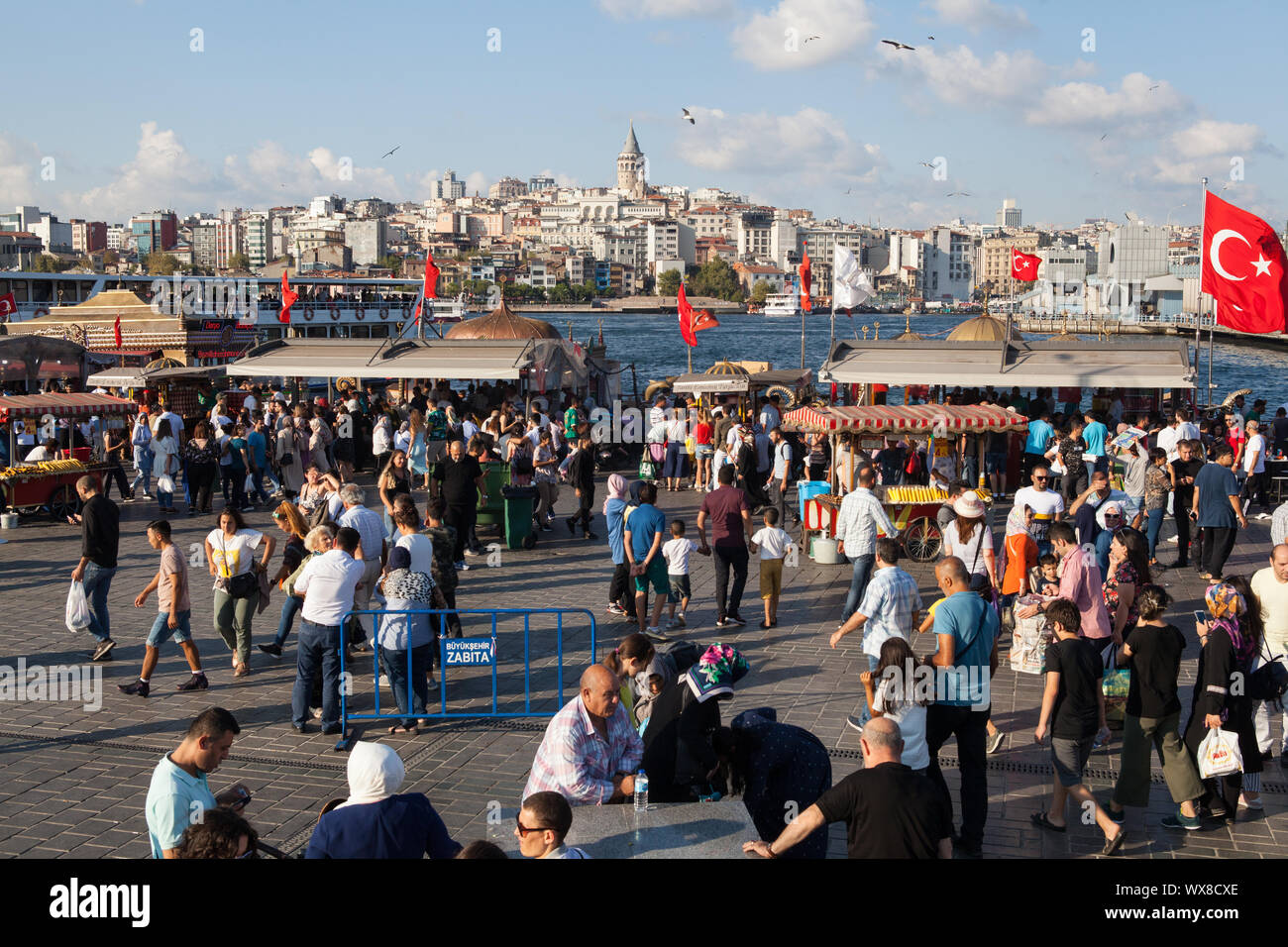 Pedestrians and fish restaurants next to the Galata Bridge in Istanbul, Turkey Stock Photo