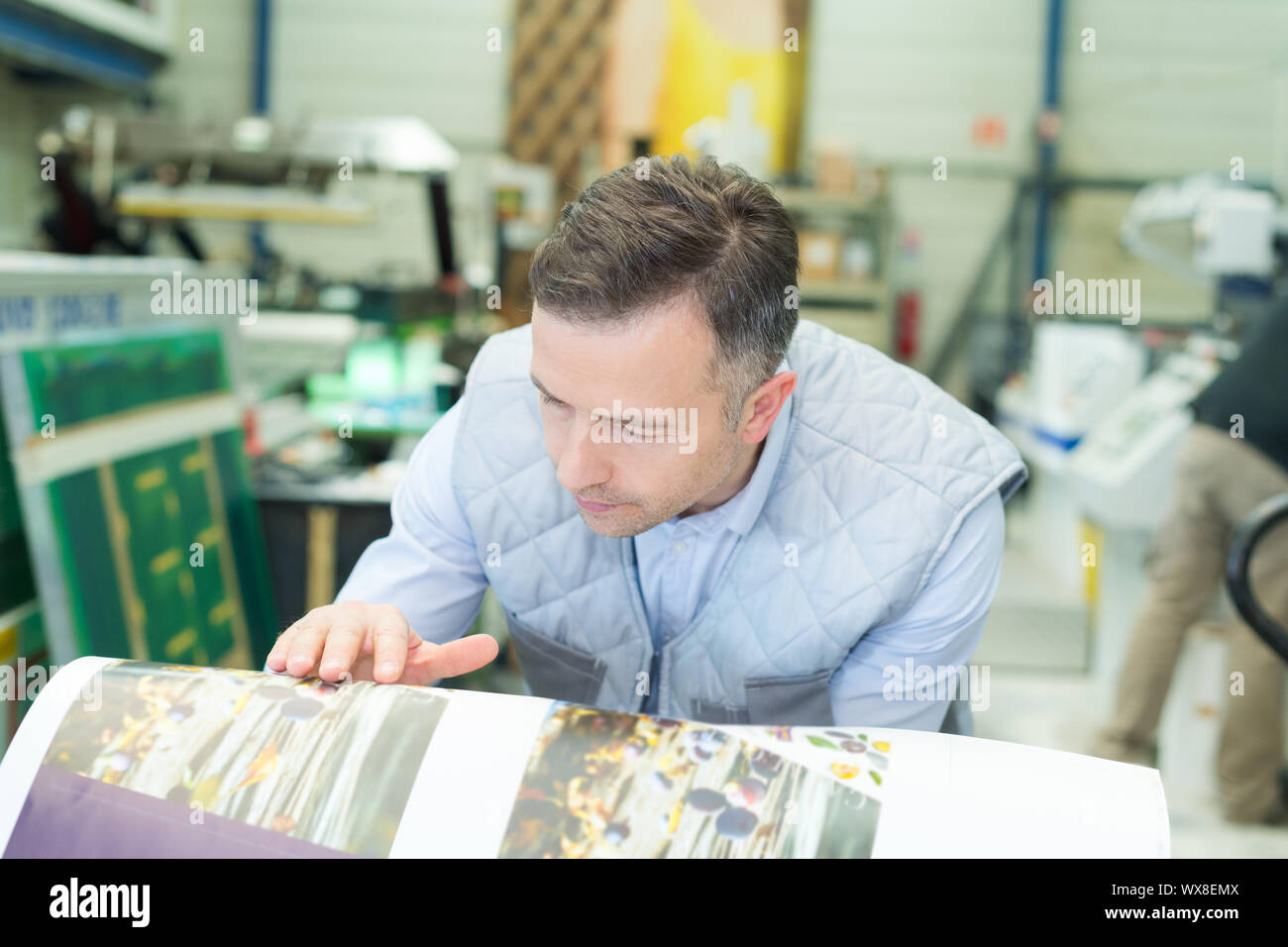 printing press supervisor checking the quality of prints Stock Photo