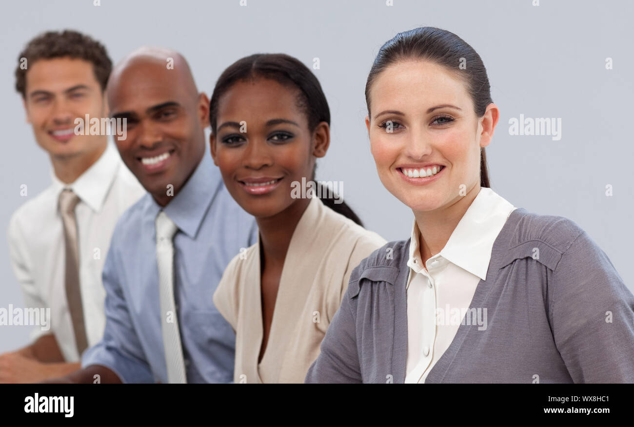 Multi-ethnic business team sitting in a row smiling at the camera Stock ...