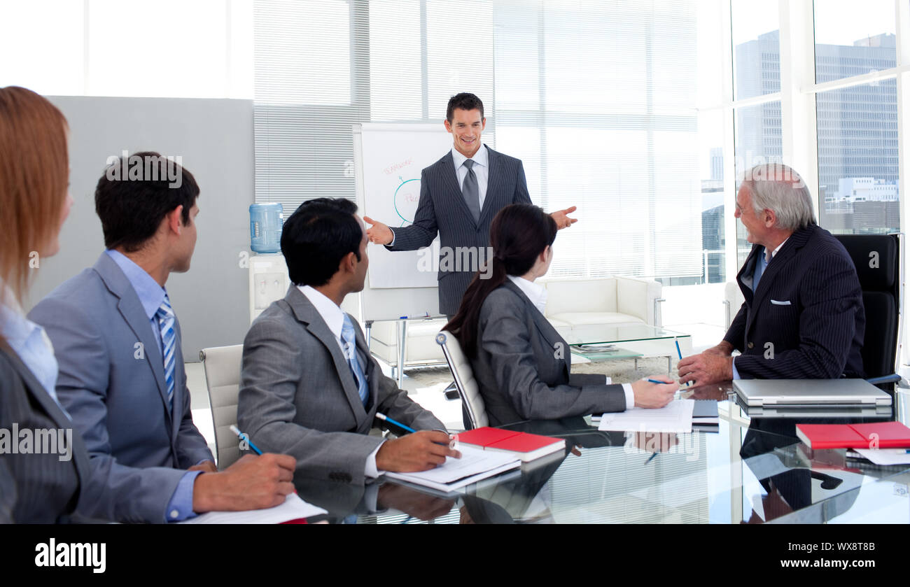 Confident businessman giving a presentation to his team in the office ...