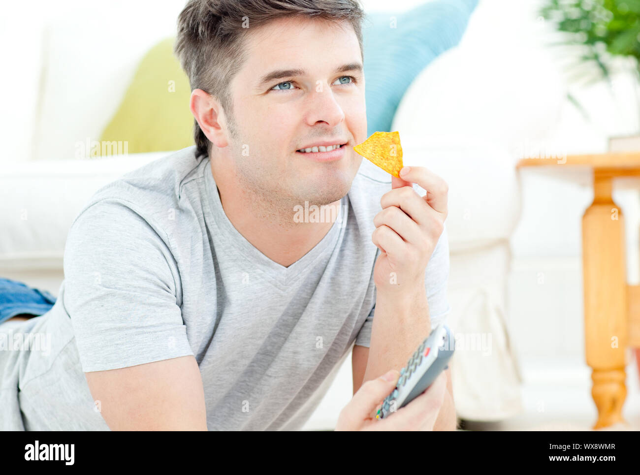 Handsome man watching TV in living room Stock Photo Alamy