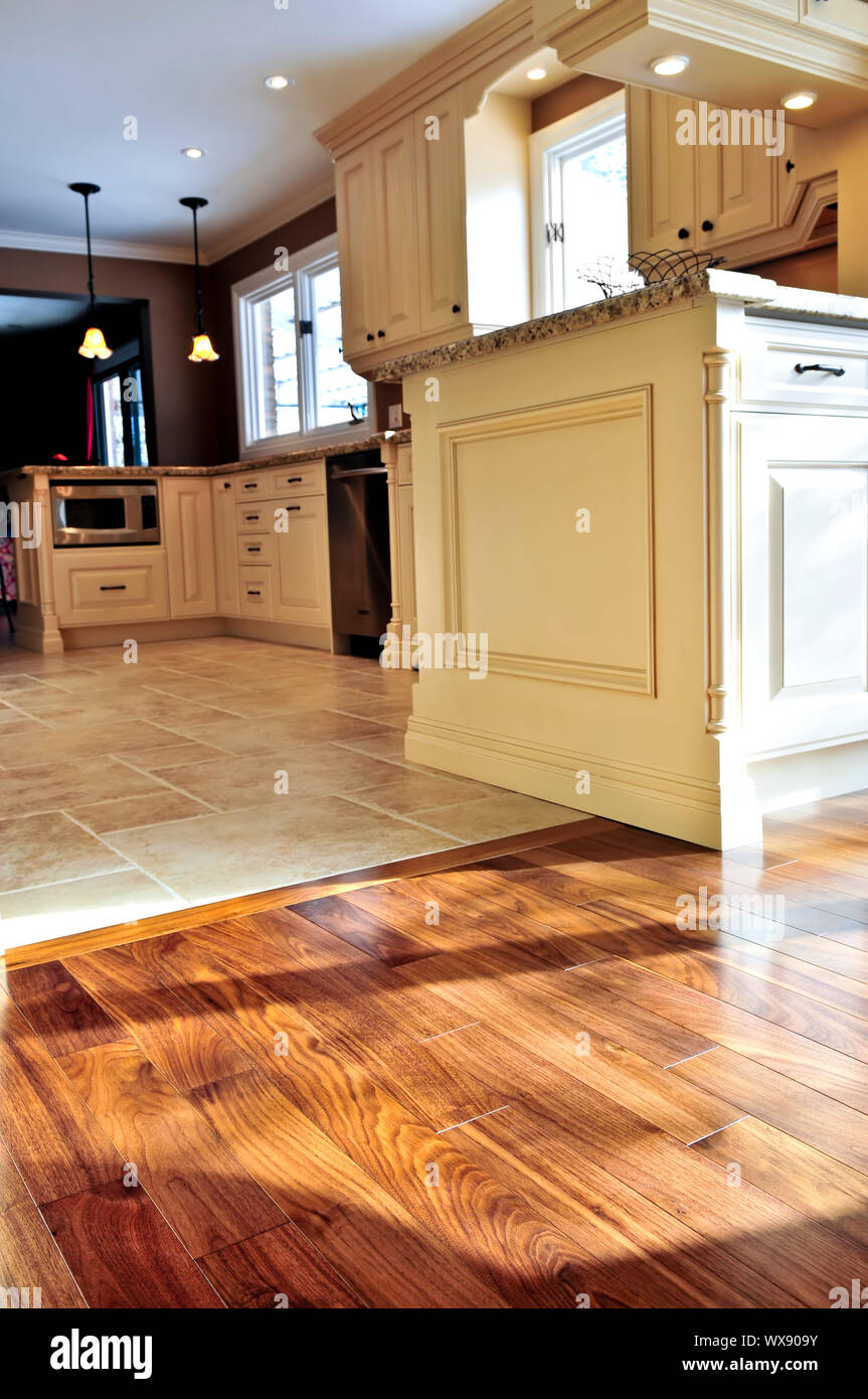 Hardwood and tile floor in residential home kitchen and dining room