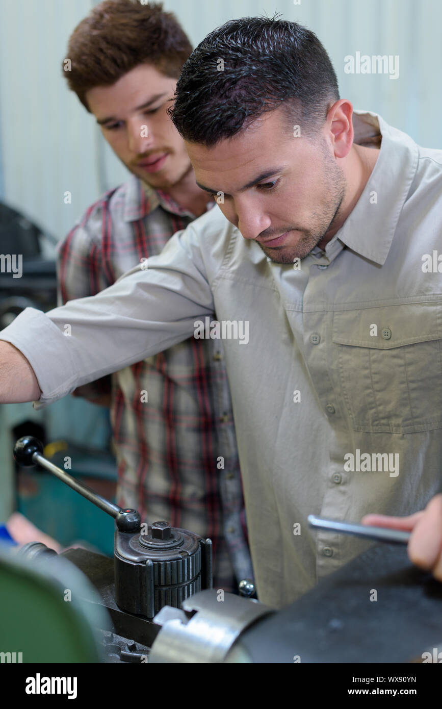man with apprentice looking at engine Stock Photo - Alamy
