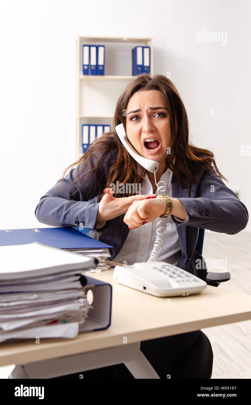 Young female employee unhappy with excessive work Stock Photo