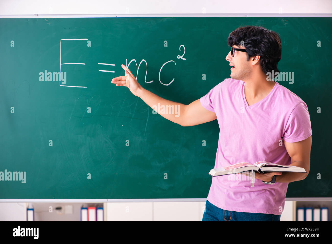 Young male physic standing in front of the green board Stock Photo