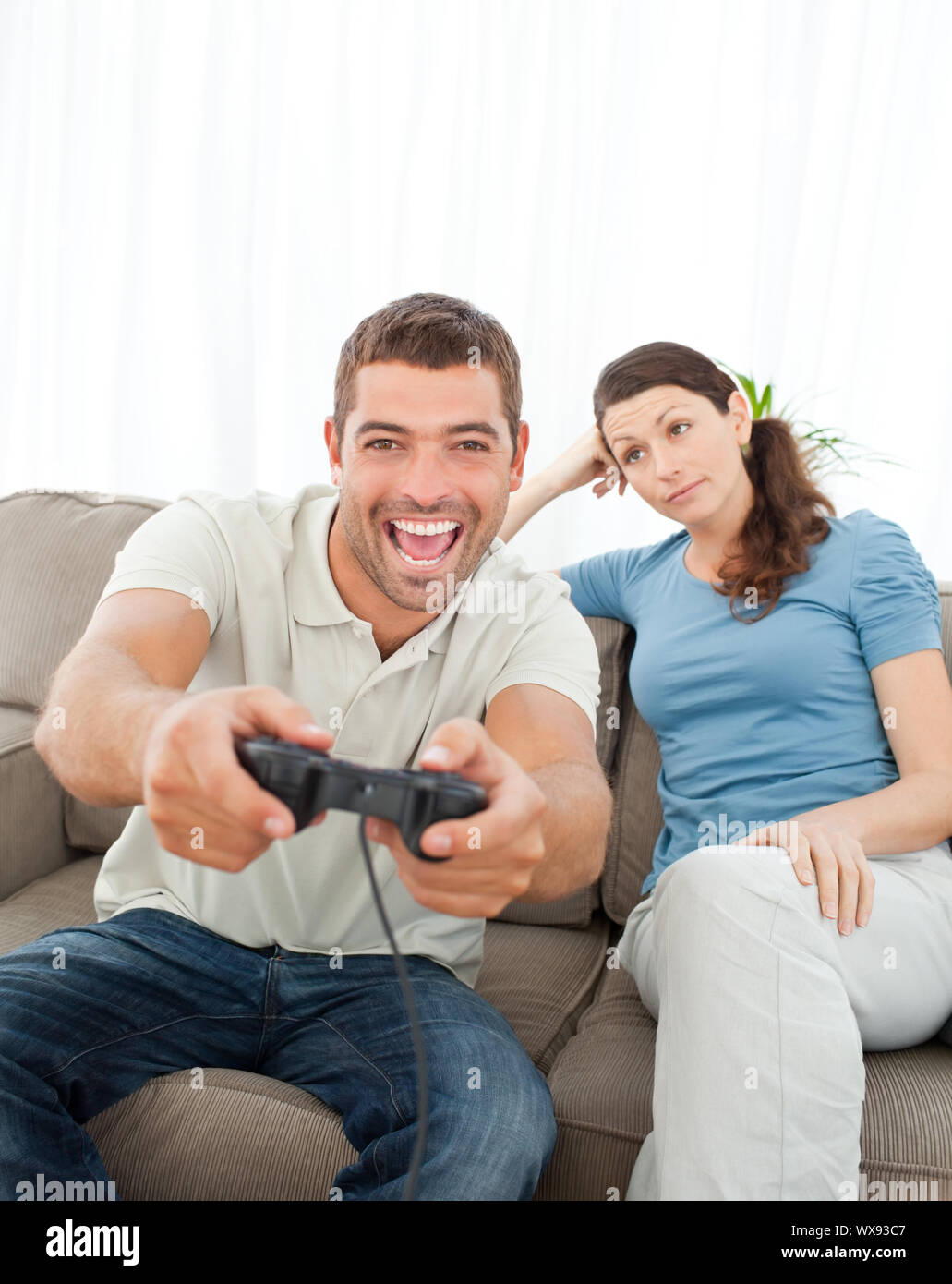 Cheerful boyfriend and girlfriend playing video games to win. Happy couple  using controller to play online game and winning gameplay on console.  People holding joystick to have fun Stock Photo - Alamy