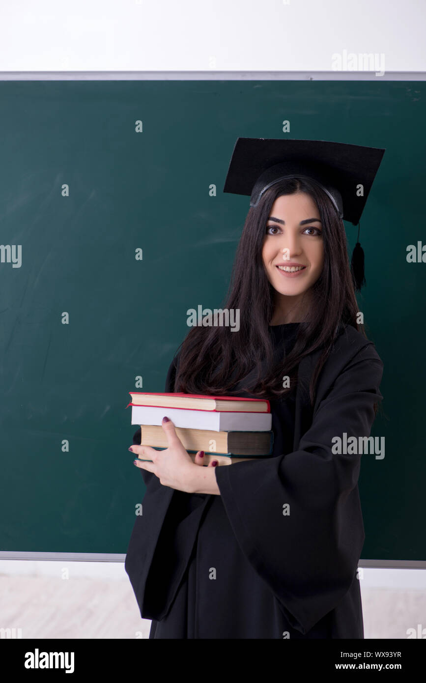 Female graduate student in front of green board Stock Photo - Alamy