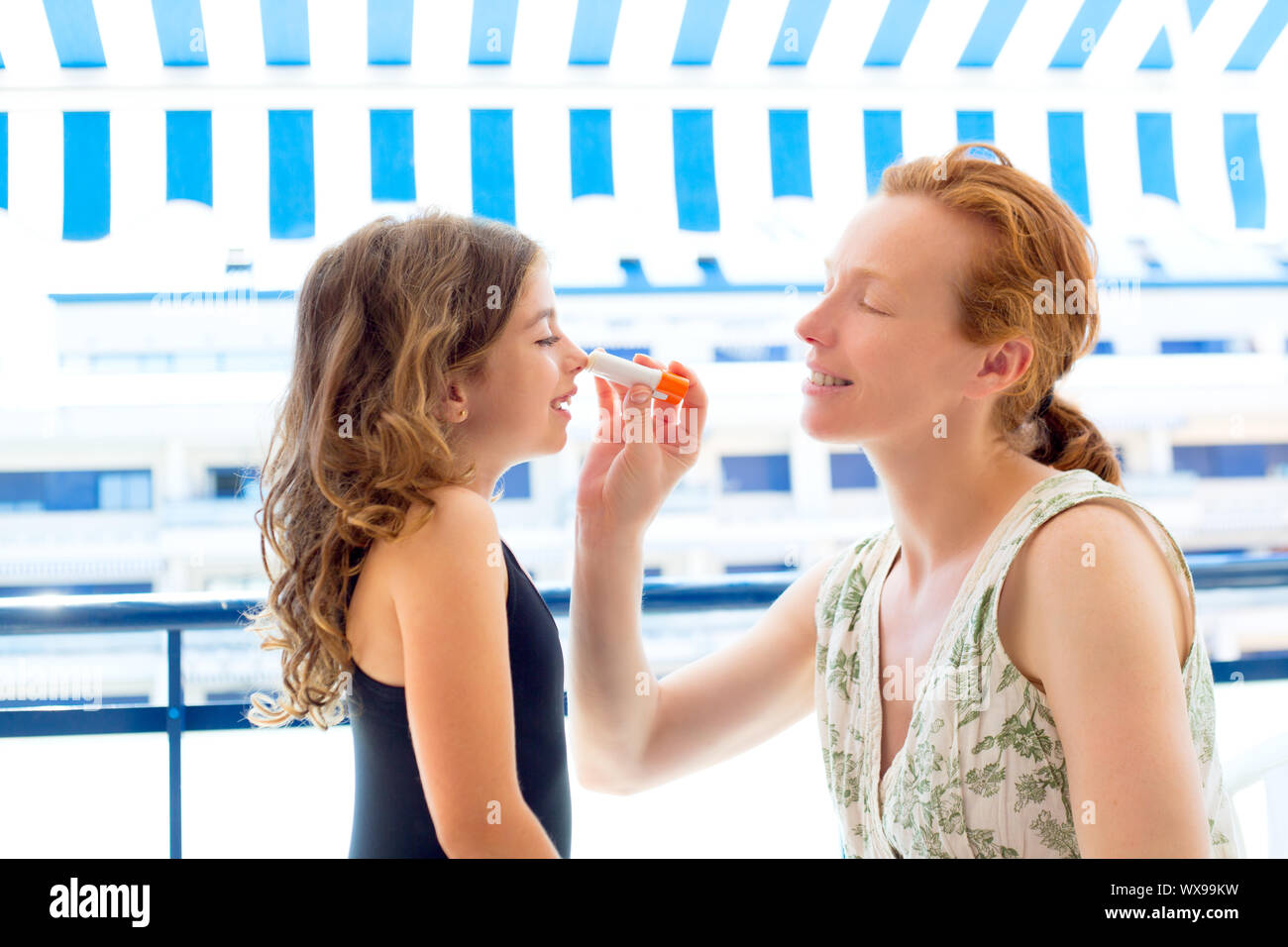 children girl with mother applying sunscreen in summer Stock Photo