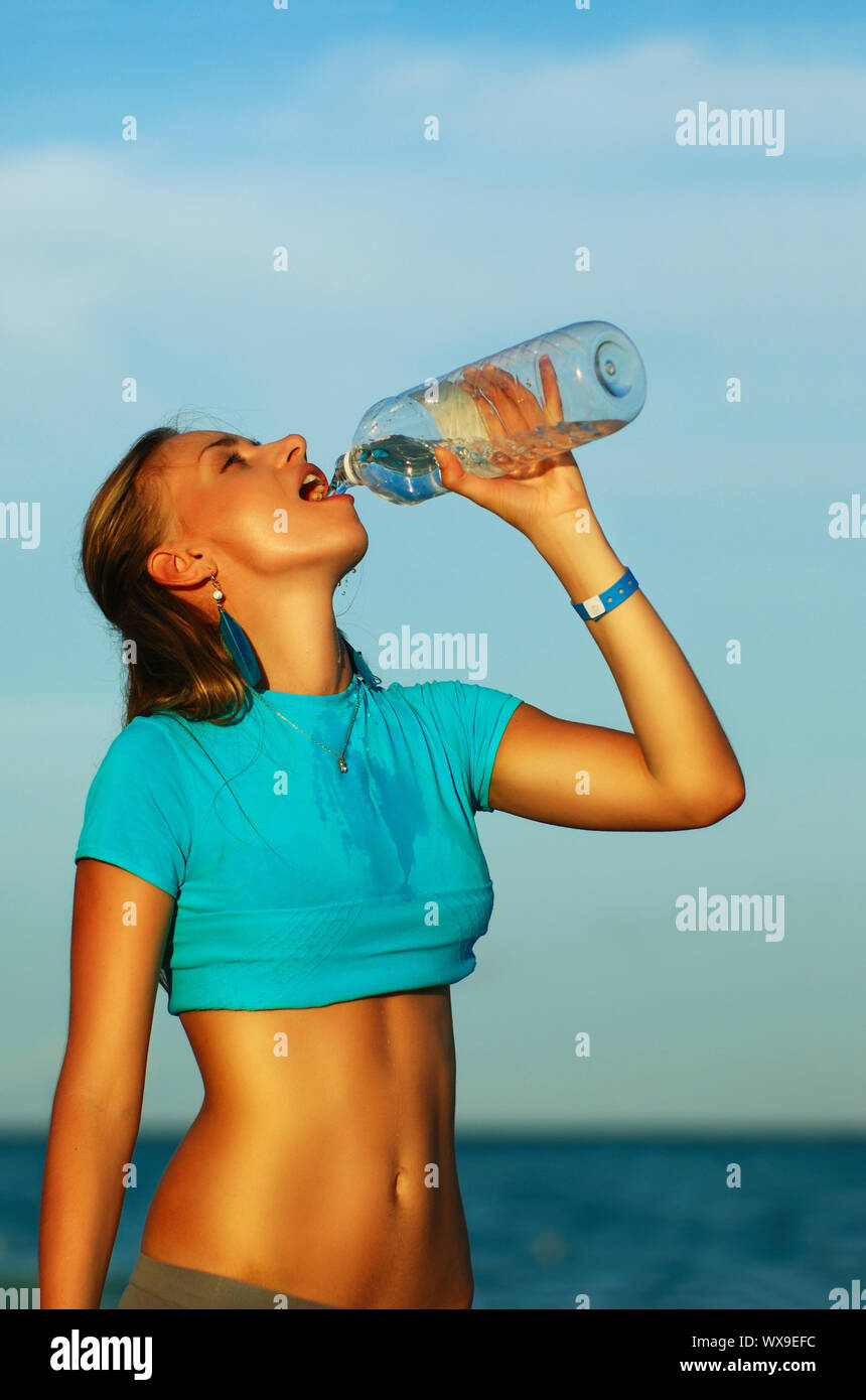 Вода после бега. Наслаждение водой питьевой. Девушка пьет воду после бега. Девушка пьет воду из бутылки после бега.