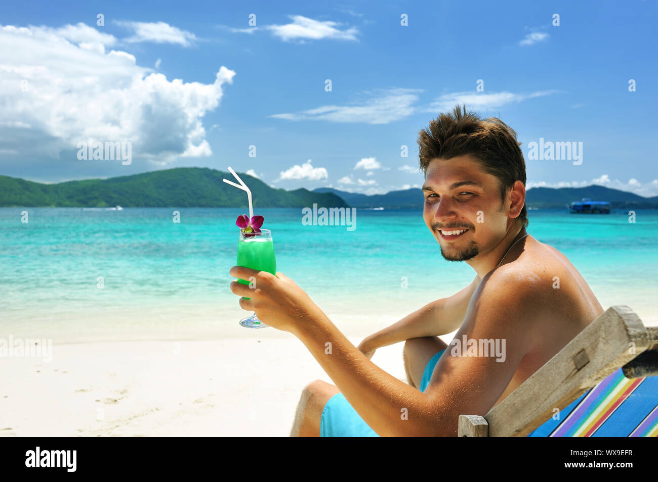 https://c8.alamy.com/comp/WX9EFR/man-on-a-beach-with-cocktail-WX9EFR.jpg