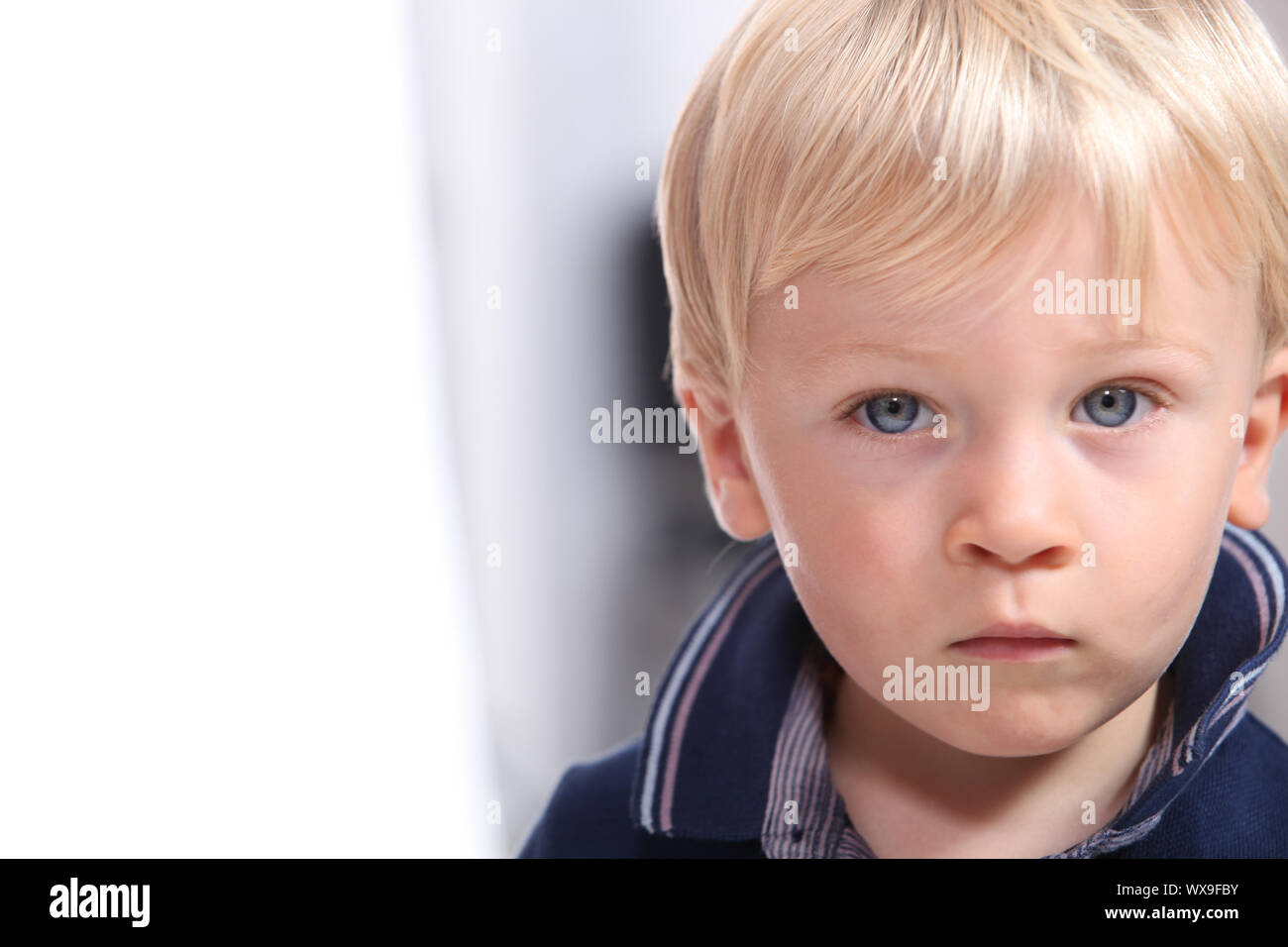 Landscape Portrait Of A Serious Little Boy With Blonde Hair And