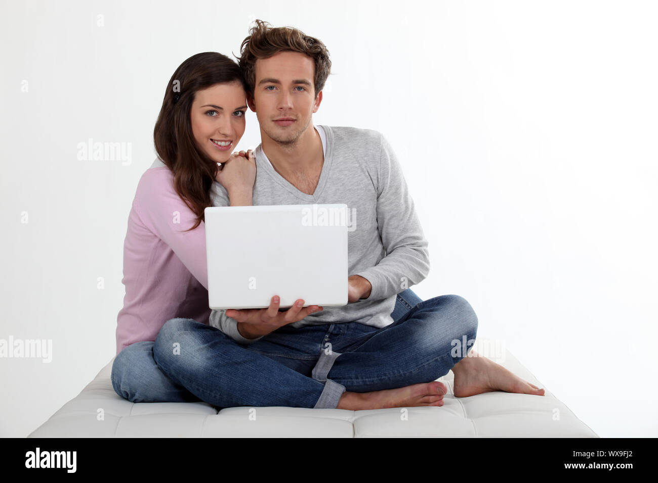 Couple using a laptop on a bed Stock Photo - Alamy
