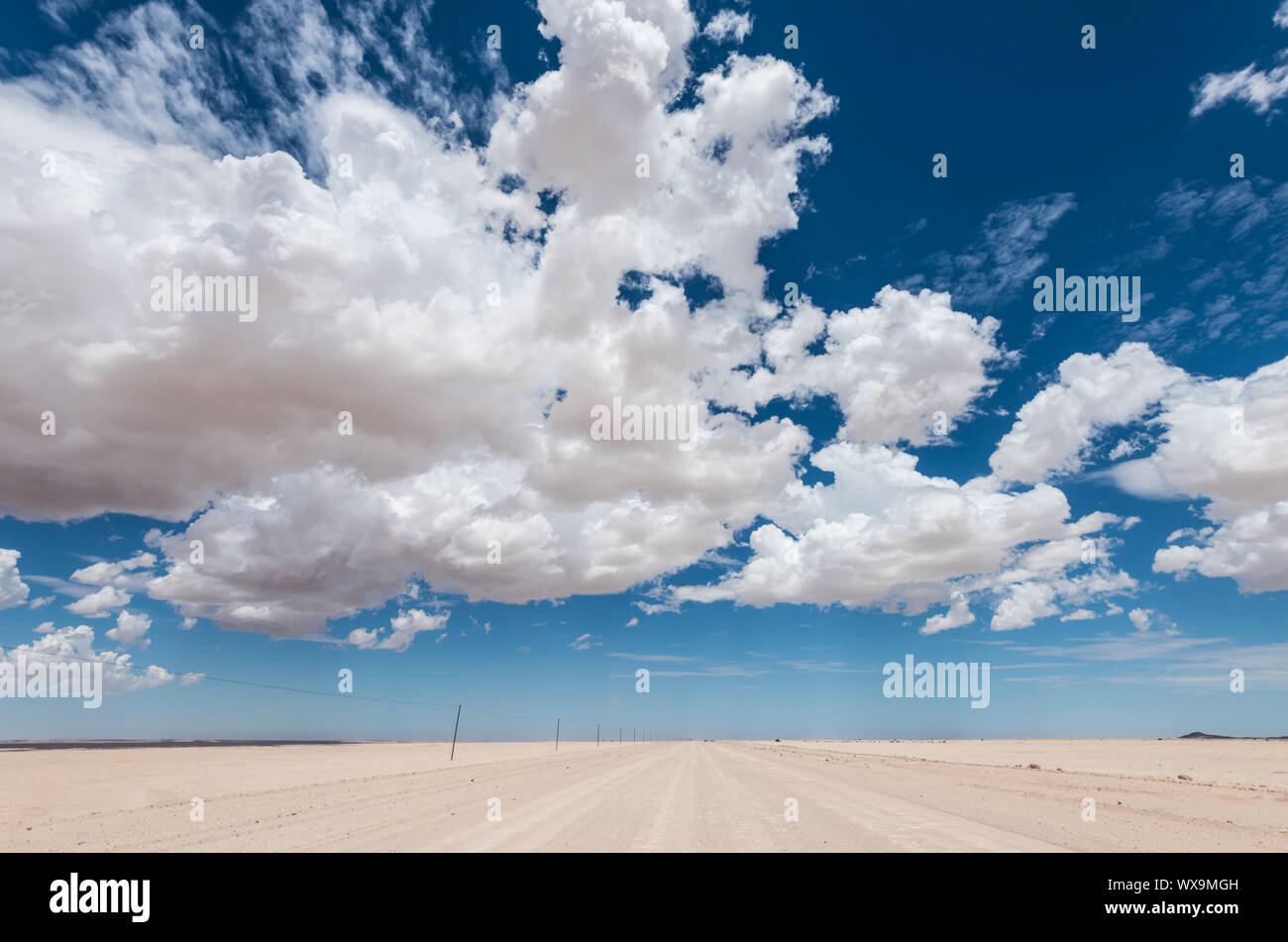 vibrant image of desert road and blue cloudy sky Stock Photo - Alamy