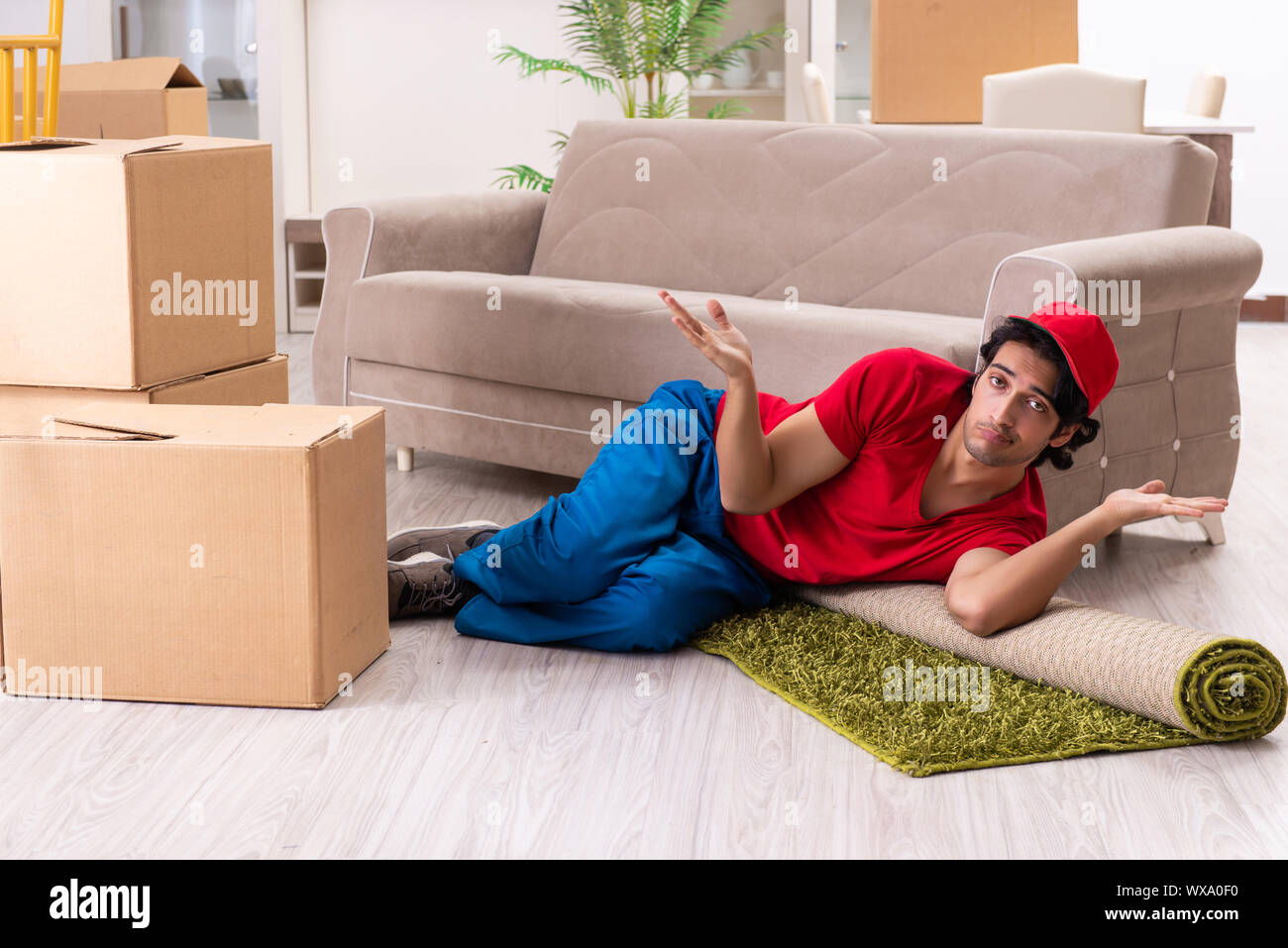 Young male contractor with boxes working indoors Stock Photo