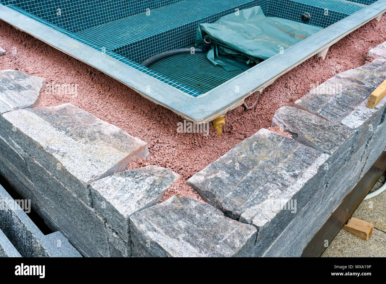 building a rock encased spa and hot tub Stock Photo - Alamy