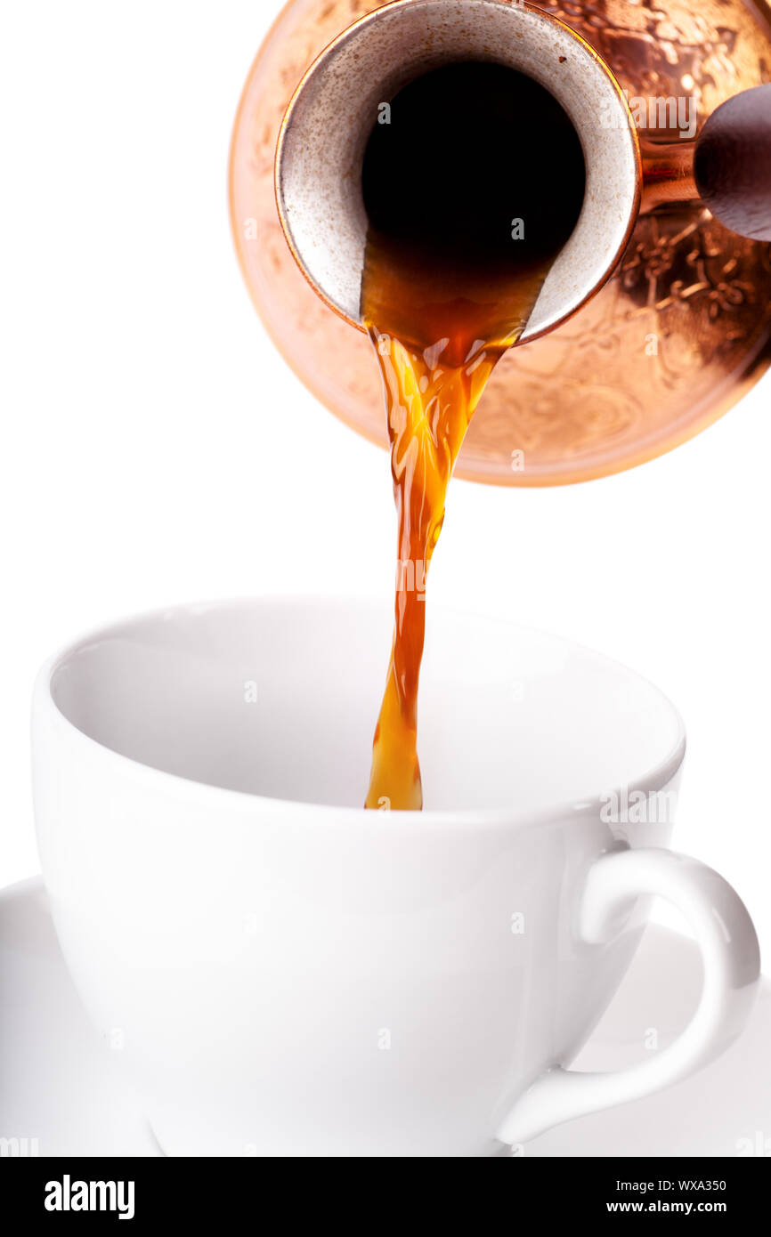 Coffee pot pouring from a copper pot to white cup Stock Photo Alamy