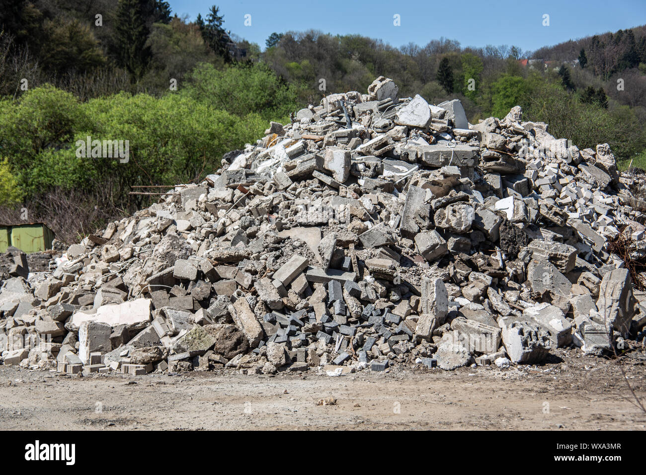 Rubble heap in front of hilly forest Stock Photo Alamy