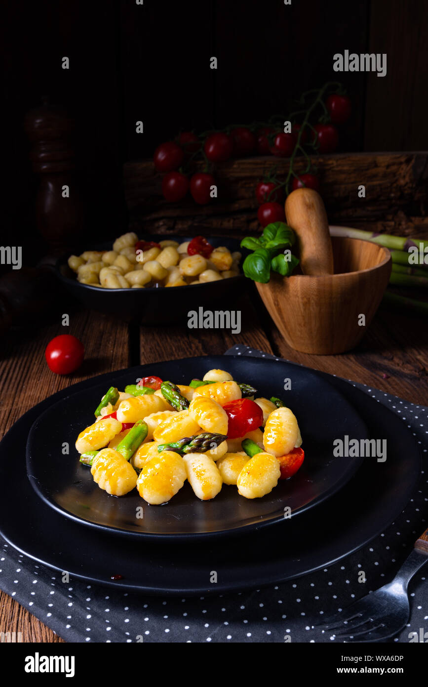 crispy gnocchi with roasted asparagus and tomatoes Stock Photo Alamy