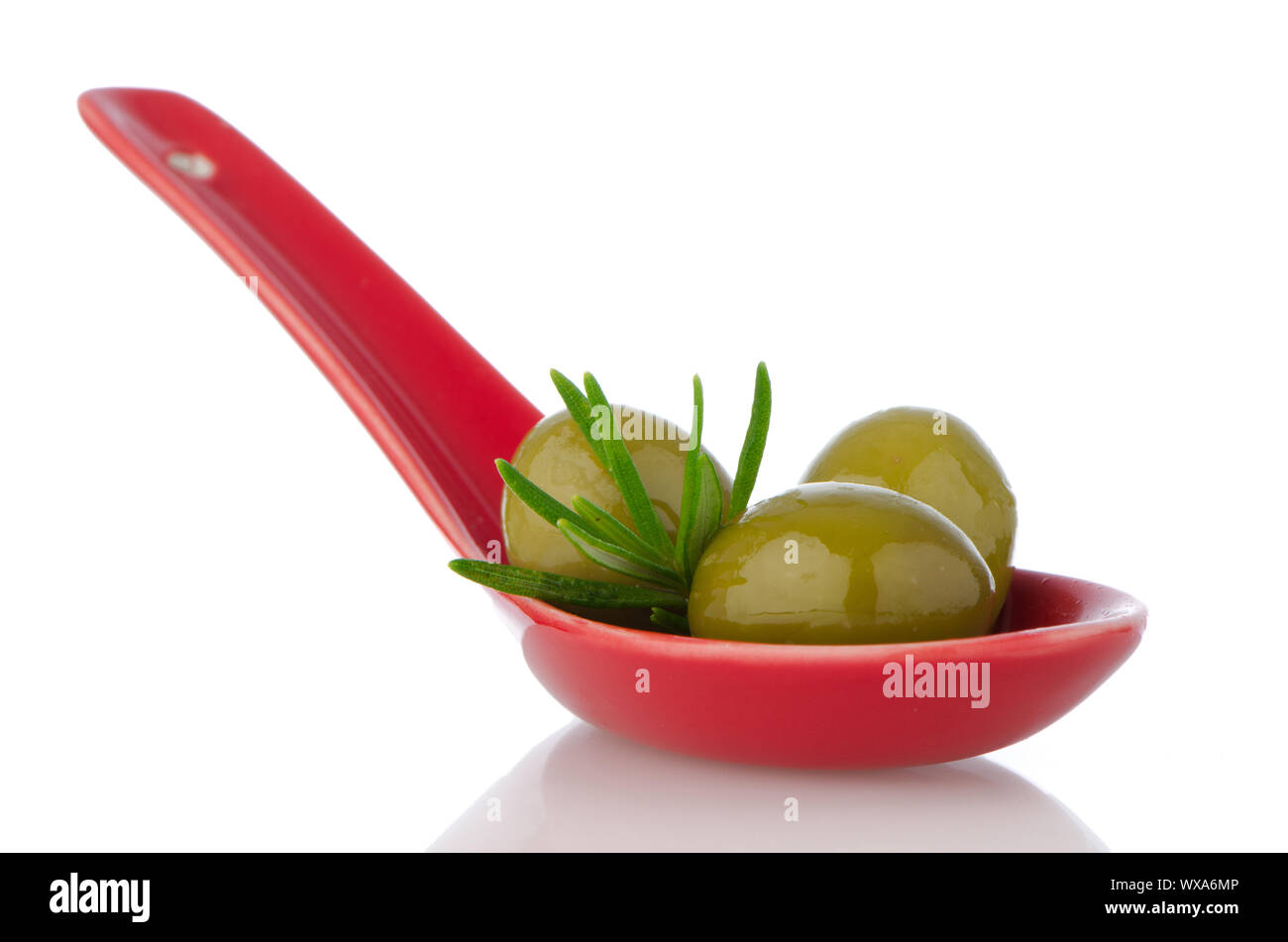 Olives on ceramic spoon with basil and olive oil Stock Photo - Alamy