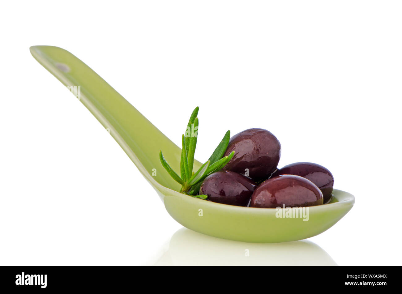 Olives on ceramic spoon with basil and olive oil Stock Photo - Alamy