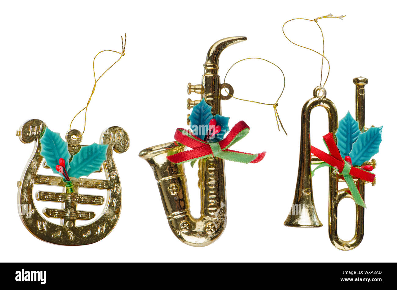 Christmas decorations, three gold plastic instruments isolated on white ...