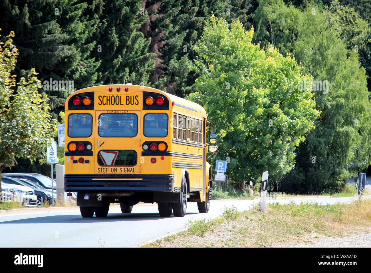 a yellow american school bus drives on the street Stock Photo