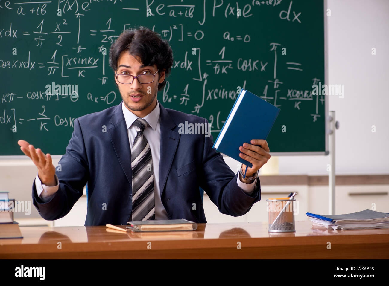 Young male math teacher in classroom Stock Photo - Alamy