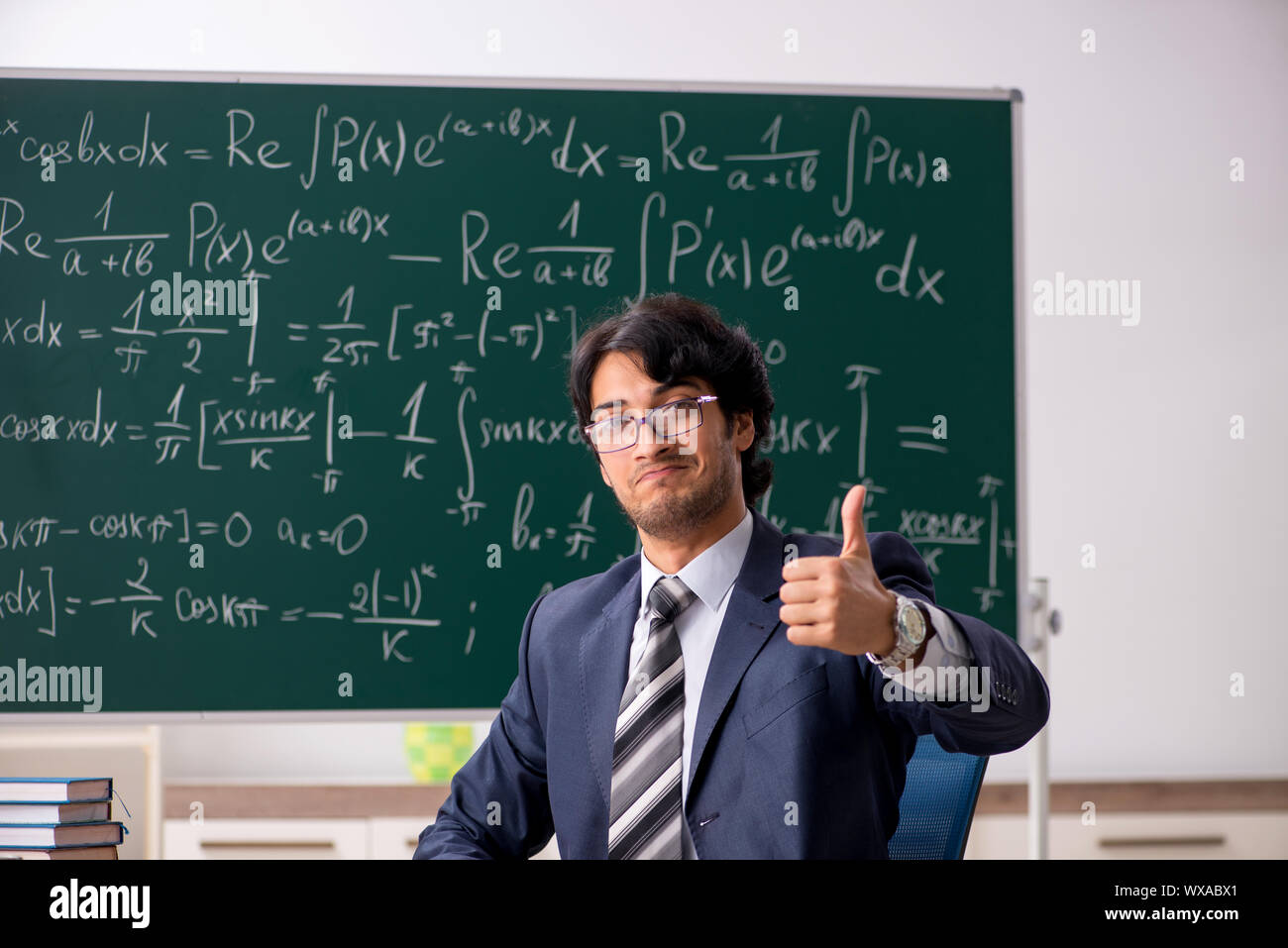 Young male math teacher in classroom Stock Photo - Alamy