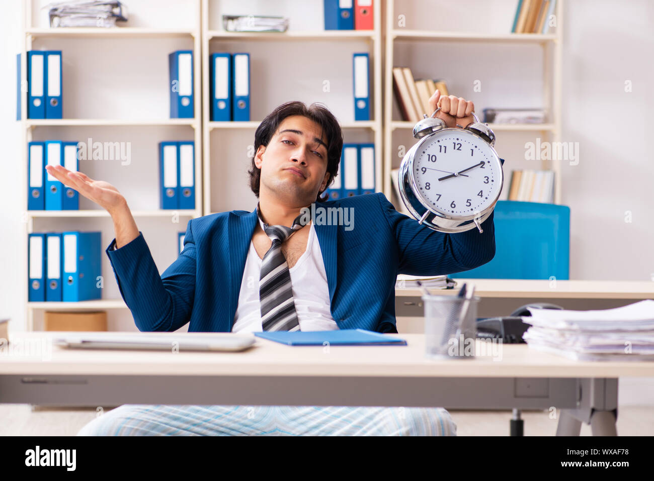 Employee coming to work straight from bed Stock Photo