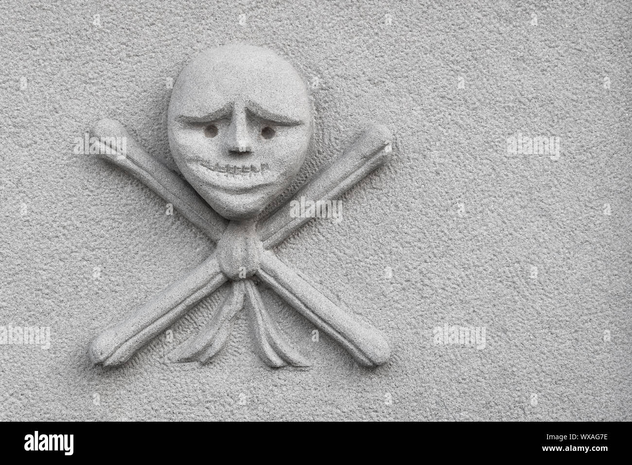 Skull and crossed bones carved on an new stone Stock Photo