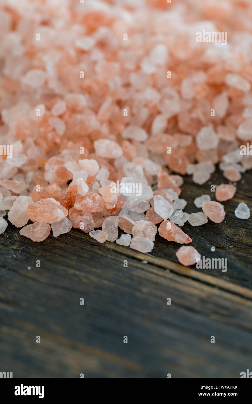 organic rose pink himalaya salt crystals on rustic wooden table Stock Photo