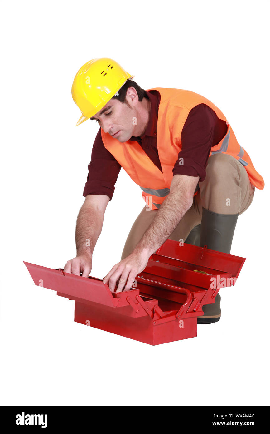 Laborer searching in  a toolbox Stock Photo