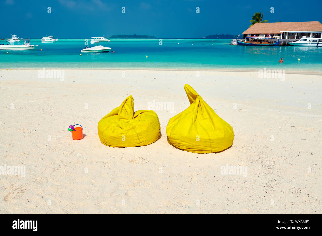 Tropical beach with yellow beanbag chairs Stock Photo