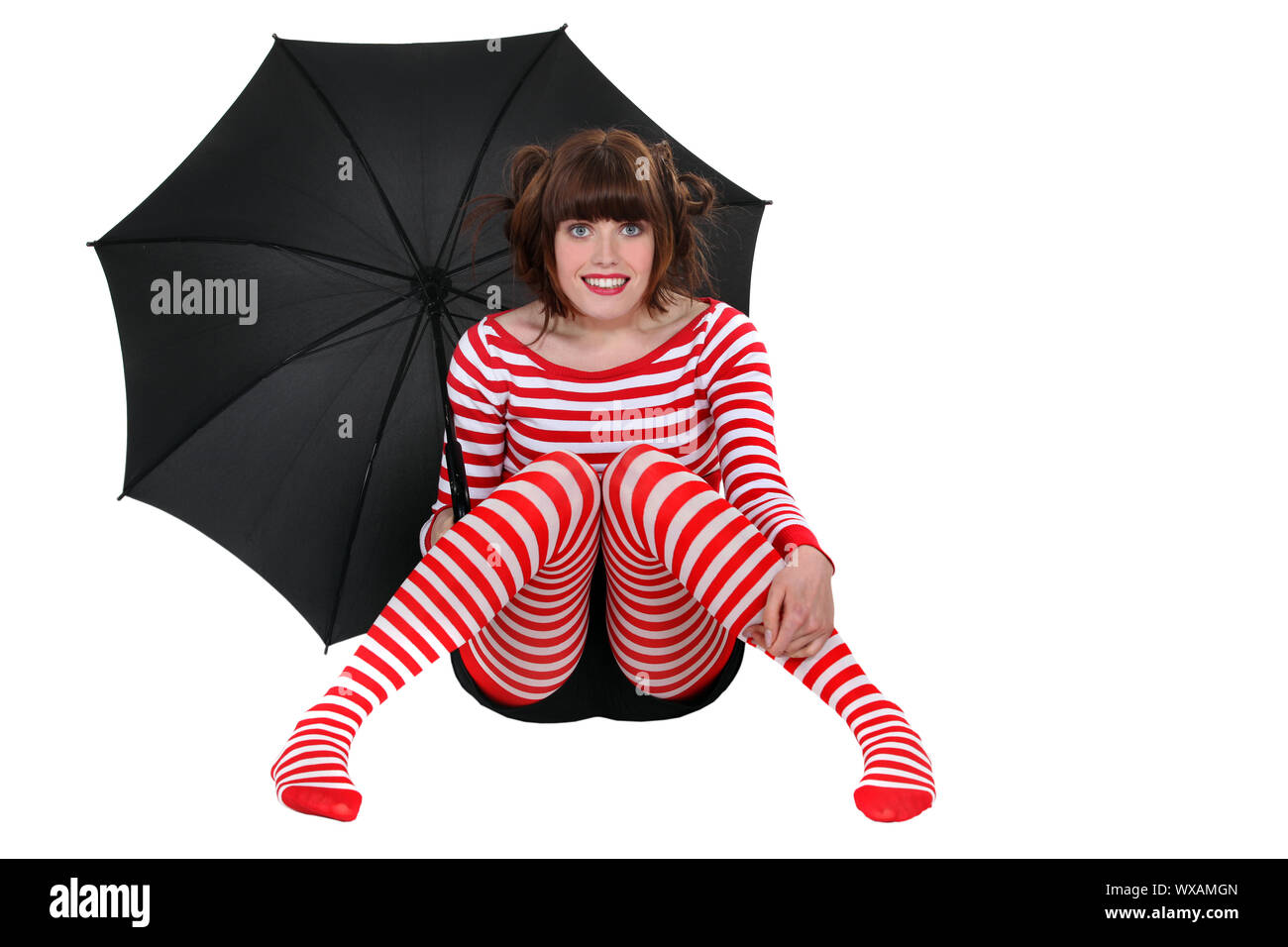 woman in striped clothes holding an umbrella Stock Photo