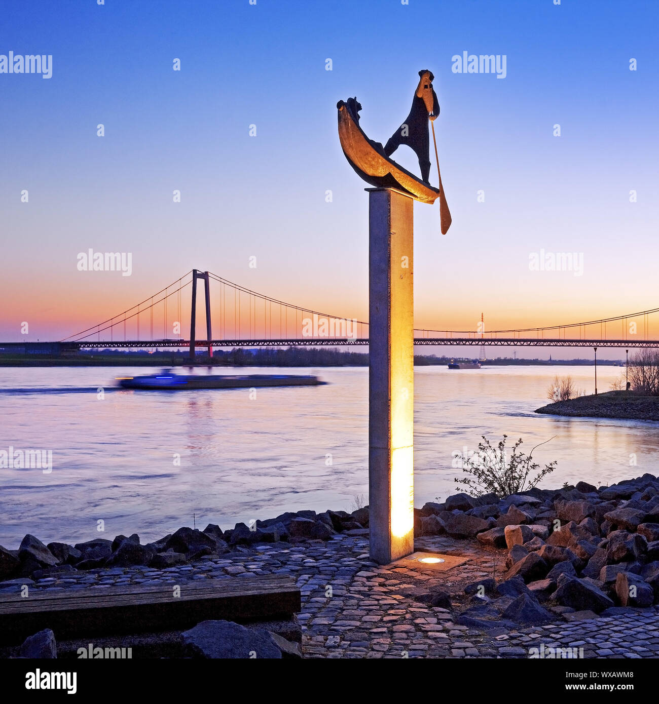 illuminated sculpture ferryman on the Rhine river bank in evening light, Emmerich, Germany, Europe Stock Photo