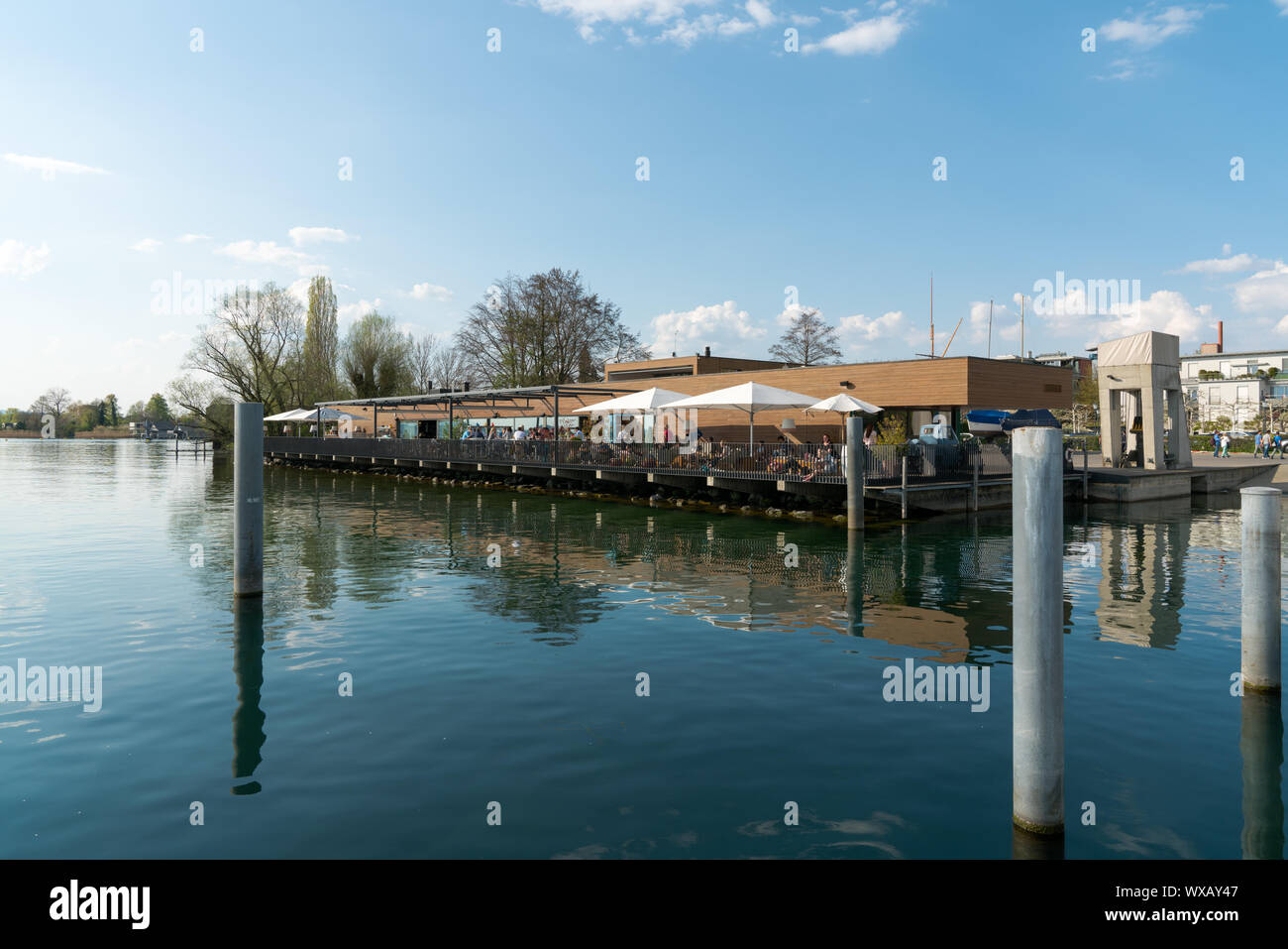 Zug, ZG / Switzerland - 20 April 2019: people enjoy dining out in the harbor restaurant on the lake Stock Photo