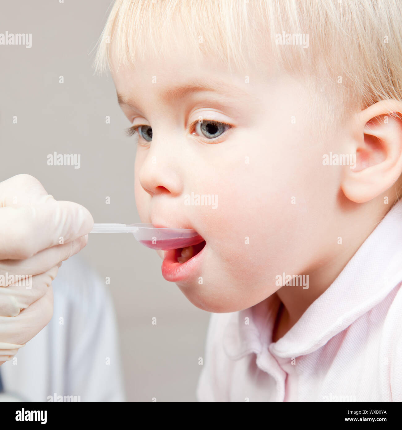 Doctor giving a spoon of syrup to cute little girl Stock Photo Alamy