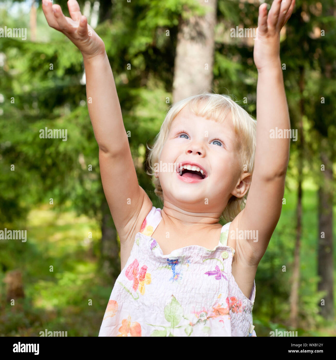 Portrait of cute little girl with hands up in happiness Stock Photo - Alamy