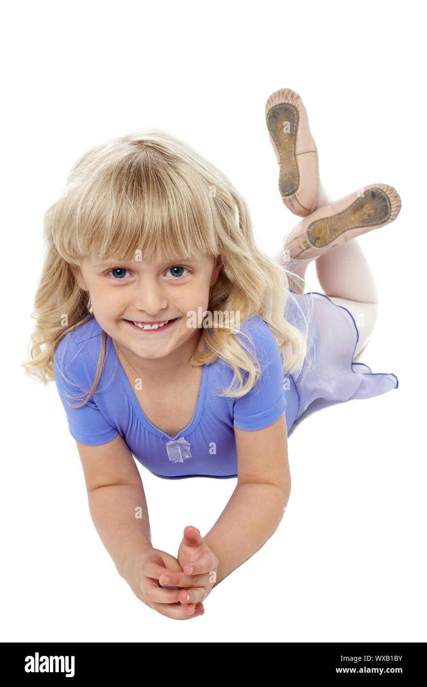 Sweet little girl posing relaxed on the floor. Legs crossed and