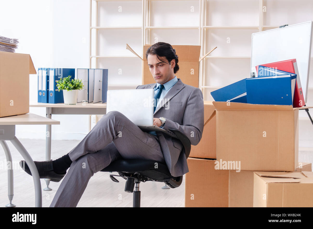 Young man employee with boxes in the office Stock Photo Alamy