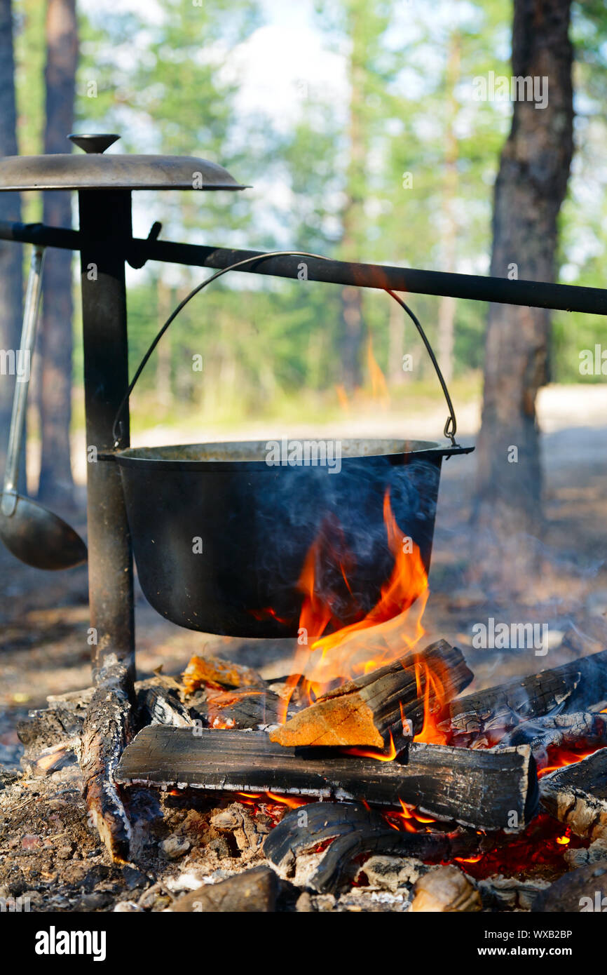 Camping kettle over burning campfire Stock Photo - Alamy