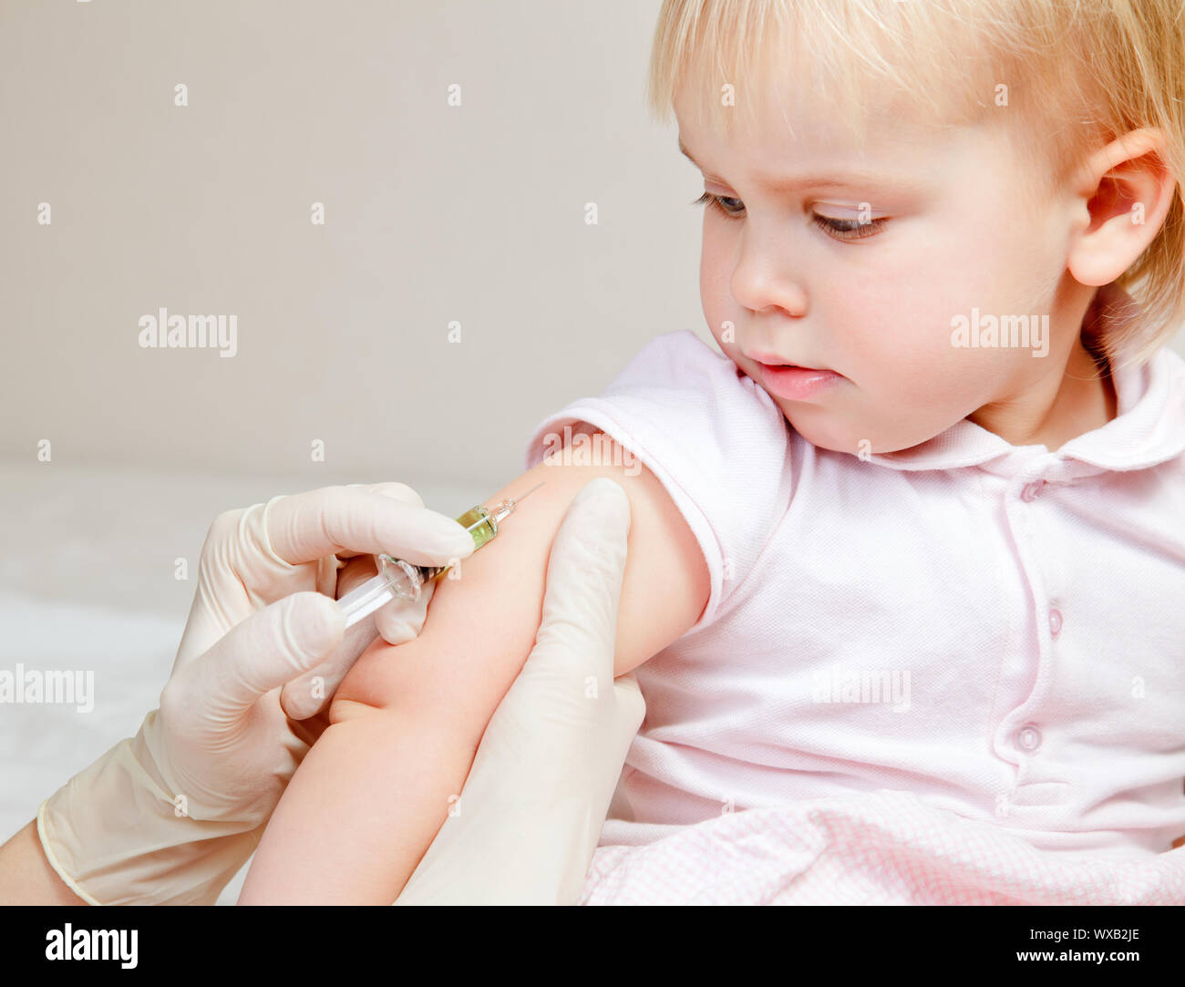 Doctor giving a child an intramuscular injection in arm Stock Photo